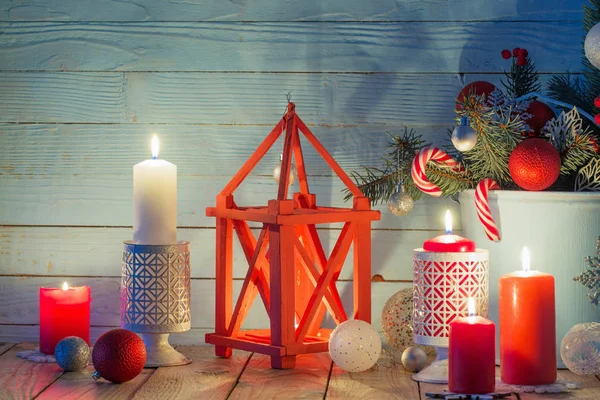 Weihnachtsdekoration mit brennenden Kerzen auf blauem Holzbackstein — Stockfoto