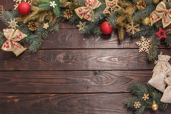 老的深色木制背景上装饰着圣诞装饰的冷杉枝条 — 图库照片
