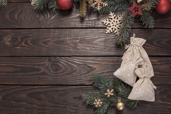 老的深色木制背景上装饰着圣诞装饰的冷杉枝条 — 图库照片