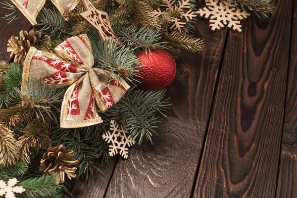 Tannenzweige mit Weihnachtsdekor auf altem dunklen Holzgrund — Stockfoto