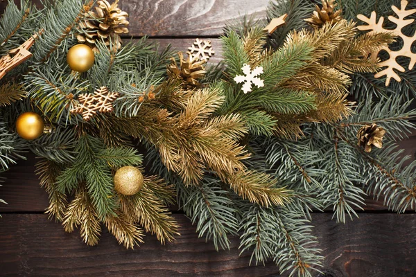 Jedle větve s vánoční výzdobou na starém tmavém dřevěném pozadí — Stock fotografie