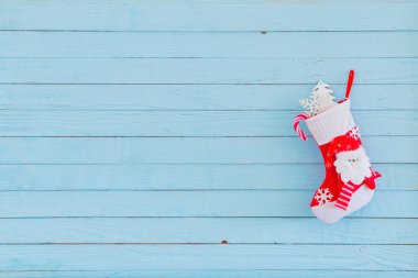 Mavi ahşap arka planda asılı hediyelerle Noel çorapları