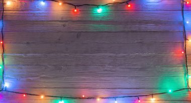 Tahta bir sörf tahtasında çok renkli ampulleri olan elektrik çelengi.