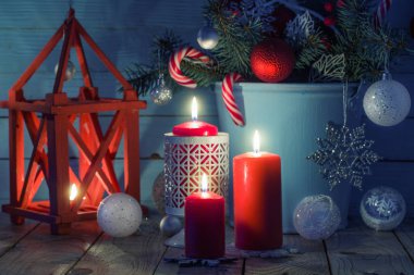 Christmas decorations with burning candles on blue wooden backgr clipart