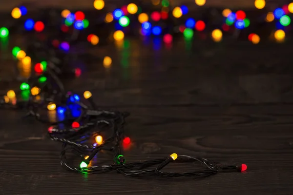 Elektromos koszorú többszínű villanykörtékkel egy fa szörfön — Stock Fotó