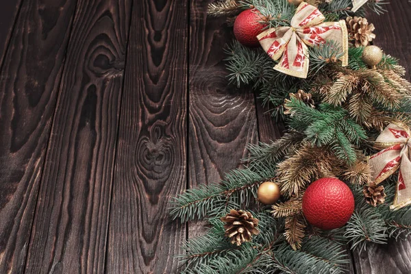 Tannenzweige mit Weihnachtsdekor auf altem dunklen Holzgrund — Stockfoto