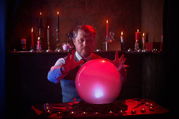 man fortune teller with illuminated crystal ball