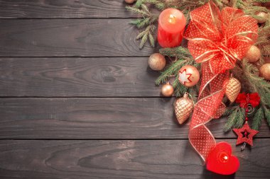 kırmızı ve altın Noel süslemesi ağaçların üzerinde yanan bir mum ile