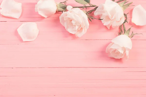 Rosas blancas sobre fondo de madera rosa — Foto de Stock