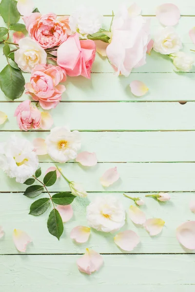 Różowe i białe róże na zielonym drewnianym tle — Zdjęcie stockowe