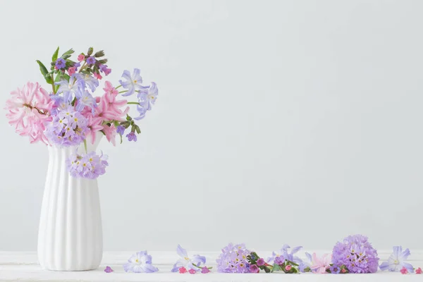 Fiori blu e rosa in vaso su tavolo bianco — Foto Stock
