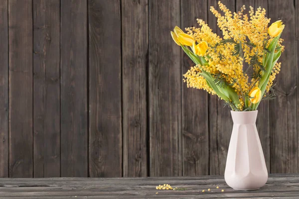 Tulipanes y mimosa en jarrón sobre fondo de madera oscura —  Fotos de Stock