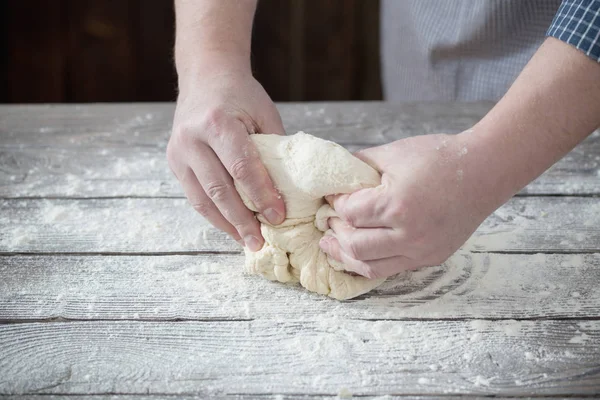Руки готують тісто на темному дерев'яному фоні — стокове фото