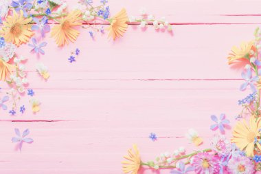 frame of beautiful flowers on pink wooden background clipart