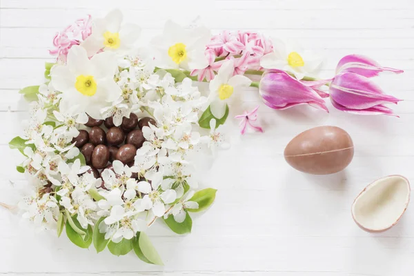 木の背景に春の花とチョコレートイースターエッグ — ストック写真