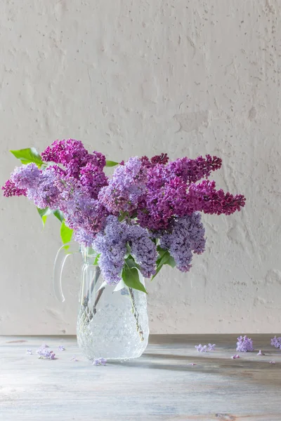 Bouquet of lilacs in a glass jug — Stock Photo, Image