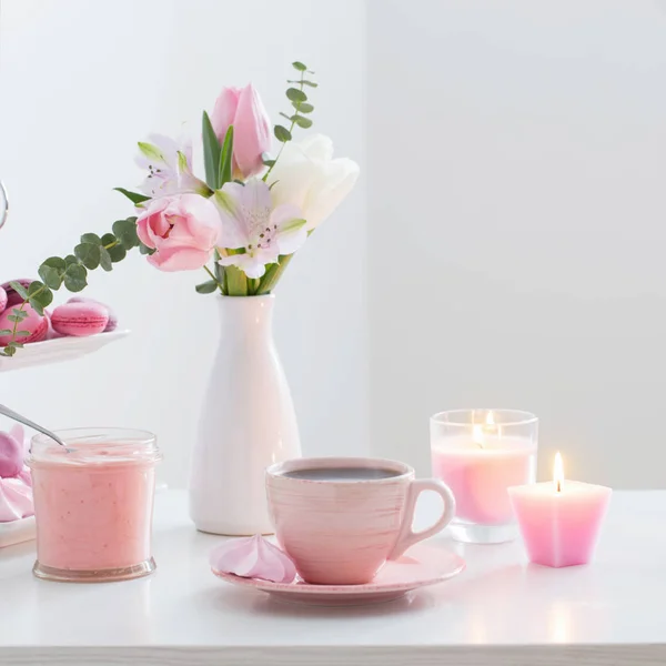 Tulipes dans un vase et une tasse de café avec dessert sur fond blanc — Photo