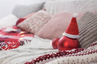 Kanepede yastıklı ve ekoseli kırmızı toplar. 