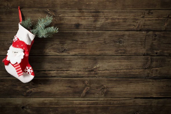 Meia de Natal com presentes pendurados no escuro velho backgro de madeira — Fotografia de Stock