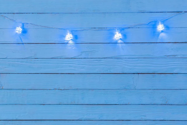 Guirlande électrique avec ampoules bleues en forme de glaçon sur bois — Photo