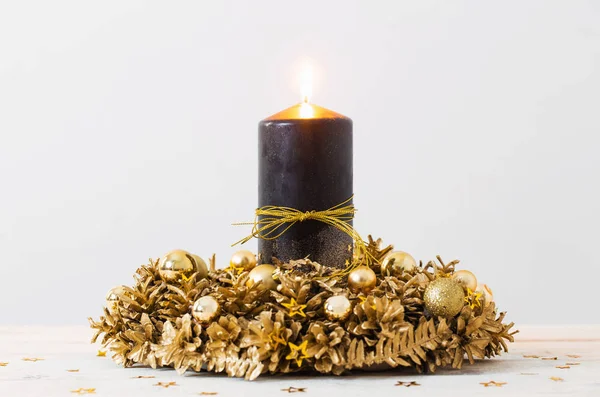 Christmas golden wreath with black burning candle on white backg — Stock Photo, Image
