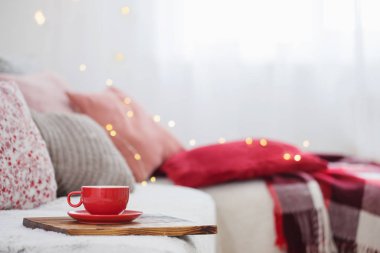 Tahta tepside kanepede bir fincan çay 