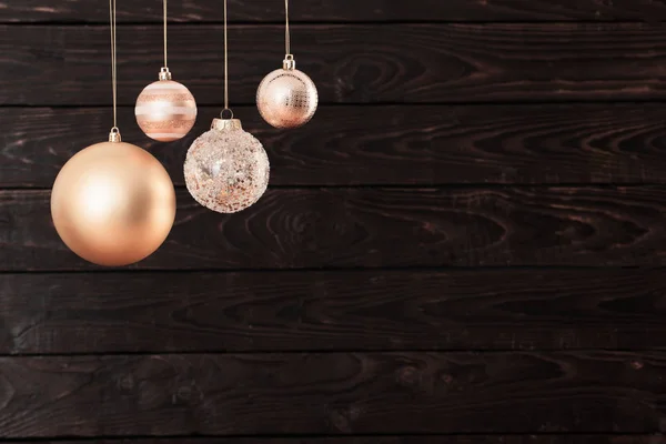 Weihnachtskugeln hängen auf dunklem Holzgrund — Stockfoto