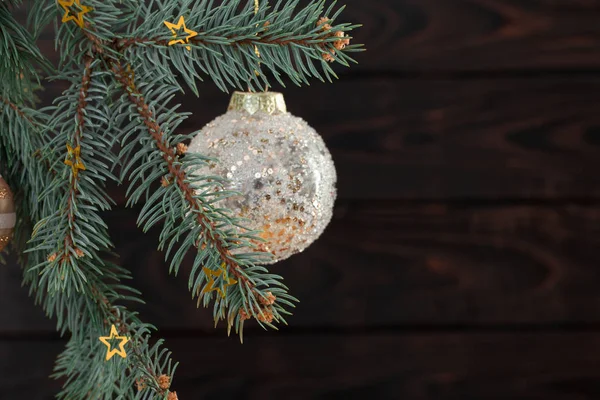 Kerstballen op sparren takken op donkere houten achtergrond — Stockfoto