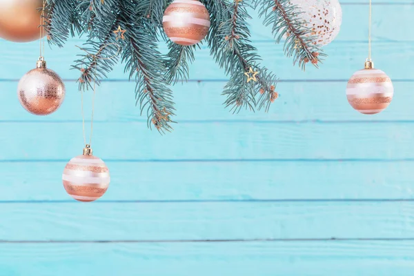 Weihnachtskugeln auf Tannenzweigen auf blauem Holzgrund — Stockfoto