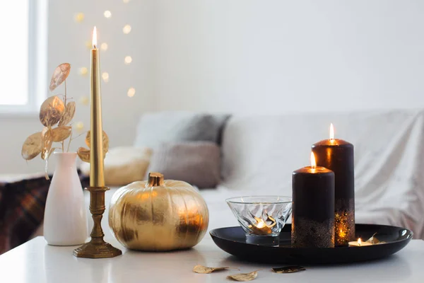 Домашний декор с золотой тыквой и горящими свечами — стоковое фото