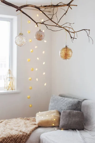 흰 실내에 있는 황금빛 가지에 달린 크리스마스 공 — 스톡 사진