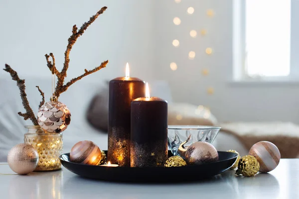 Черные горящие свечи с рождественскими шарами в белом интерьере — стоковое фото