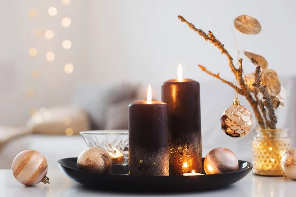 Velas ardientes negras con bolas de Navidad en el interior blanco —  Fotos de Stock