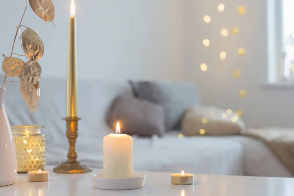 Queimando velas na mesa no interior branco — Fotografia de Stock