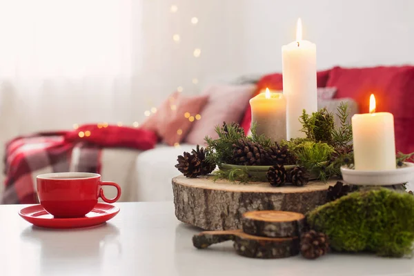 Чашка чая с горящими свечами на белом столе — стоковое фото