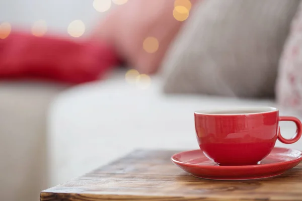 Filiżanka herbaty na drewnianej tacy na sofie — Zdjęcie stockowe