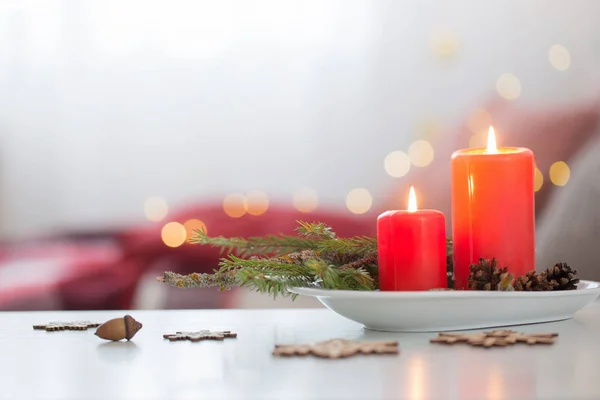 Rote brennende Kerzen auf weißem Tisch im Wohnzimmer — Stockfoto