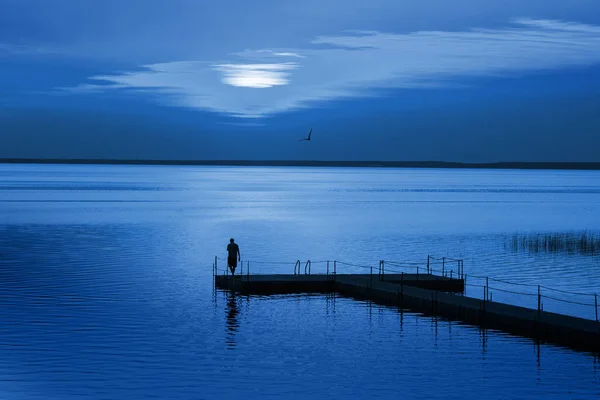 Homem no cais do pontão na noite azul. Cor do ano 2020 Classi — Fotografia de Stock