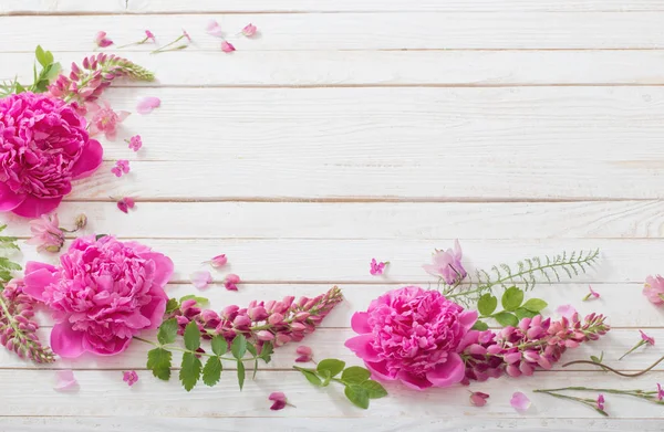 Růžové nádherné květiny na bílém dřevěném pozadí — Stock fotografie