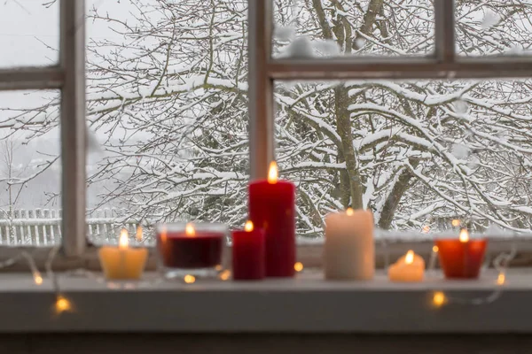 Burning candles on a windowsill — Stock Photo, Image