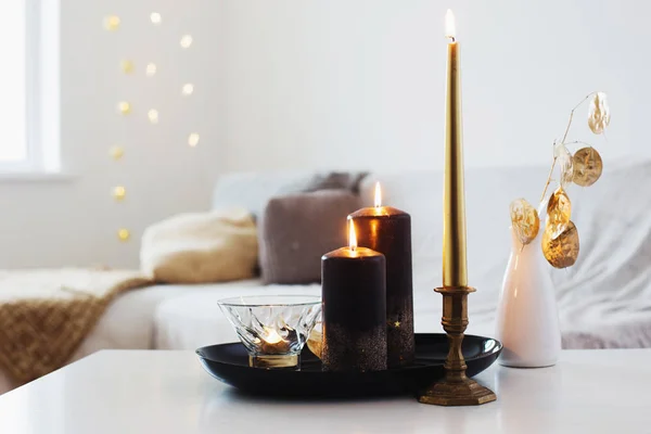 Černé a zlaté svíčky na bílém stole — Stock fotografie