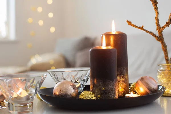 Czarne płonące świece z kulkami świątecznymi w białym wnętrzu — Zdjęcie stockowe