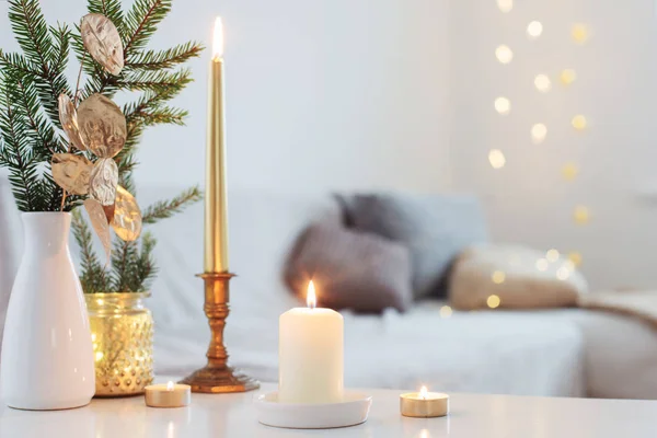 Decoraciones navideñas con velas encendidas en el interior blanco —  Fotos de Stock