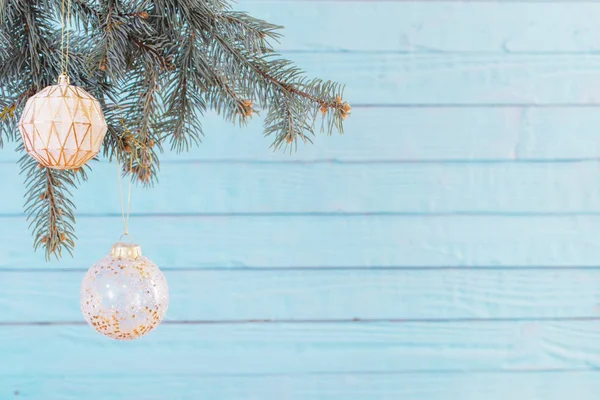 Weihnachtskugeln auf Tannenzweigen auf blauem Holzgrund — Stockfoto