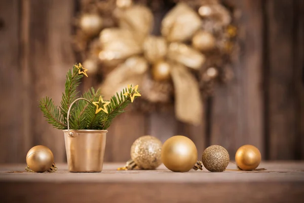 Bolas de oro de Navidad, ramas de abeto y corona en madera oscura —  Fotos de Stock