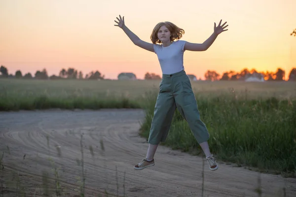 Funny teenager girl jumping outdoor at sunset — Stock Photo, Image