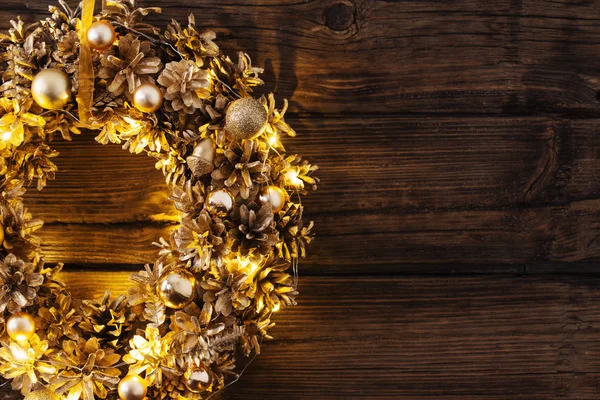 Couronne dorée de Noël sur un vieux fond en bois sombre — Photo