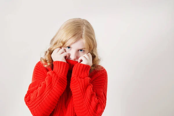 Девушка в красном свитере на белом фоне — стоковое фото