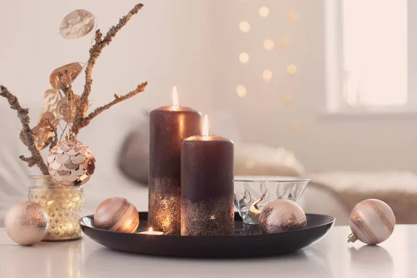 Velas ardientes negras con bolas de Navidad en el interior blanco —  Fotos de Stock