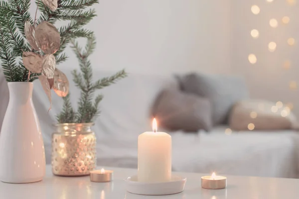 Vánoční dekorace s hořícími svíčkami v bílém interiéru — Stock fotografie